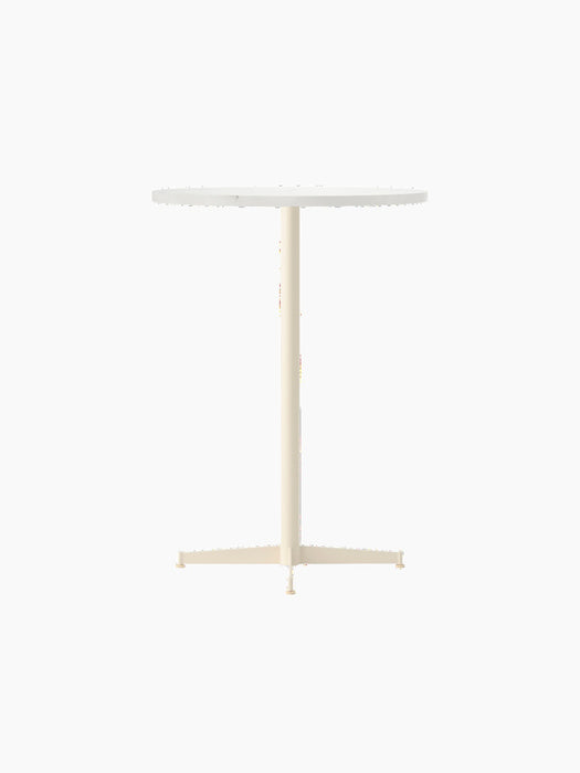 Angle view of the Nook Bar Table with a round white top and an ivory pedestal base with four feet, on a black background.