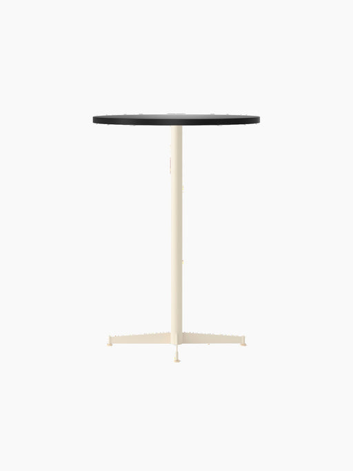 An angled shot of the Nook Bar Table with a round, charcoal linoleum tabletop and a slim, ivory-coloured pedestal base.