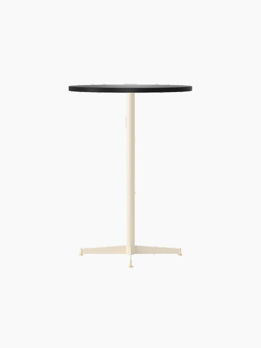 An angled shot of the Nook Bar Table with a round, charcoal linoleum tabletop and a slim, ivory-coloured pedestal base.