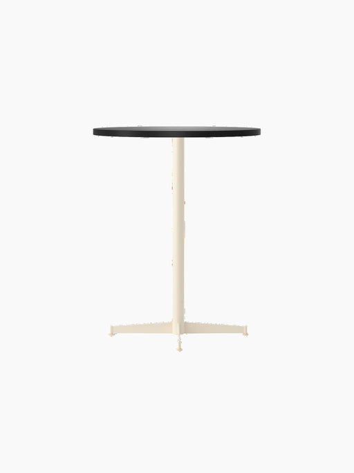 An angle view of the Nook Counter Table, featuring a round, charcoal linoleum tabletop and a slender, ivory-coloured base.