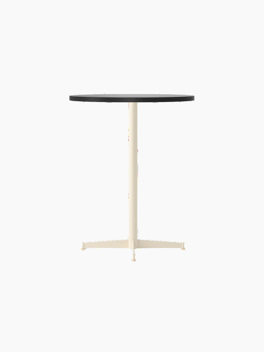 An angled view of the Nook Counter Table, featuring a round, charcoal linoleum top and a slender, ivory-coloured metal base.