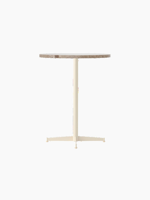 Angle view of the Nook Counter Table with a round Kunis Breccia stone top and an ivory powder-coated steel base.
