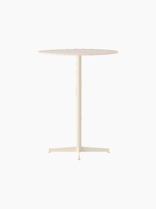 Angled Nook Bar Table with a round top and slender, four-legged ivory base against a black background.