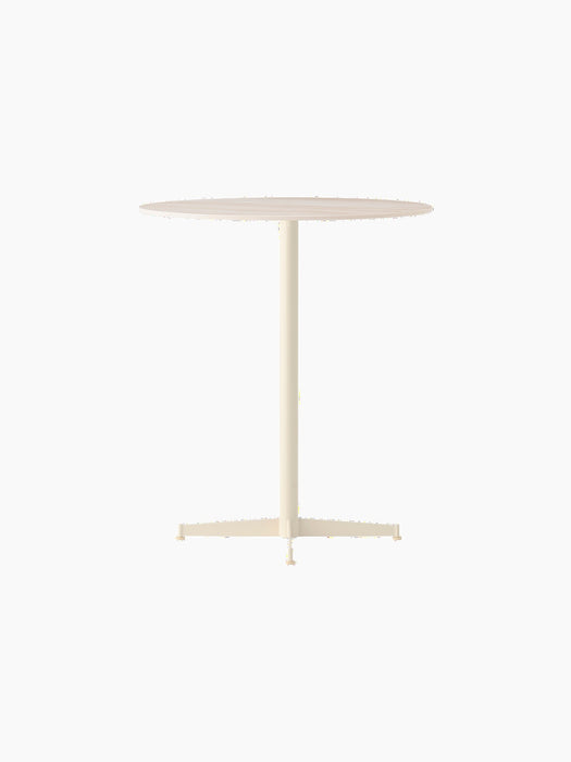 Nook Counter Table in an ivory finish, seen from an angle. It has a circular top, slim central leg and a four-star base.
