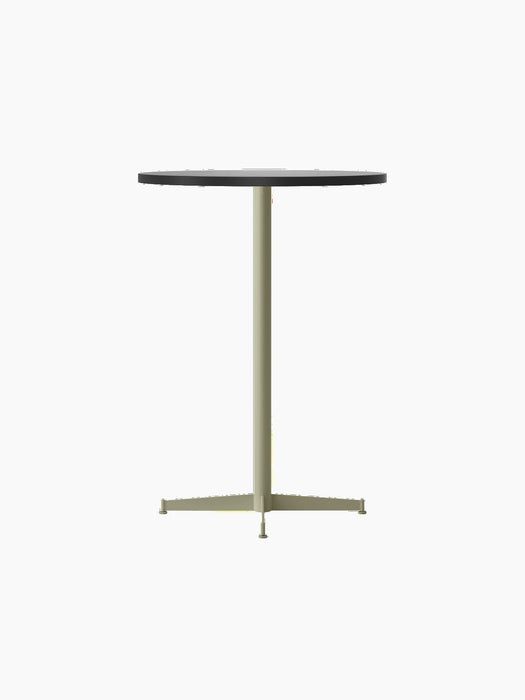 An angled view of the Nook Bar Table, featuring a round, dark grey tabletop and a slender, ivory-coloured pedestal base.