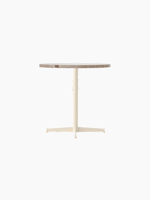 Side view of the Nook Dining Table with a round Kunis Breccia stone top and an ivory powder-coated steel four-star base.