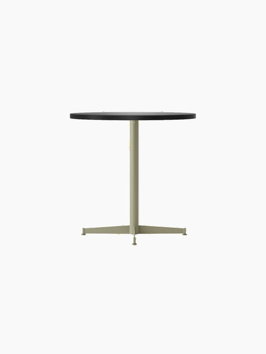 Angle view of the Nook Dining Table with a round, dark tabletop and an olive four-star pedestal base.
