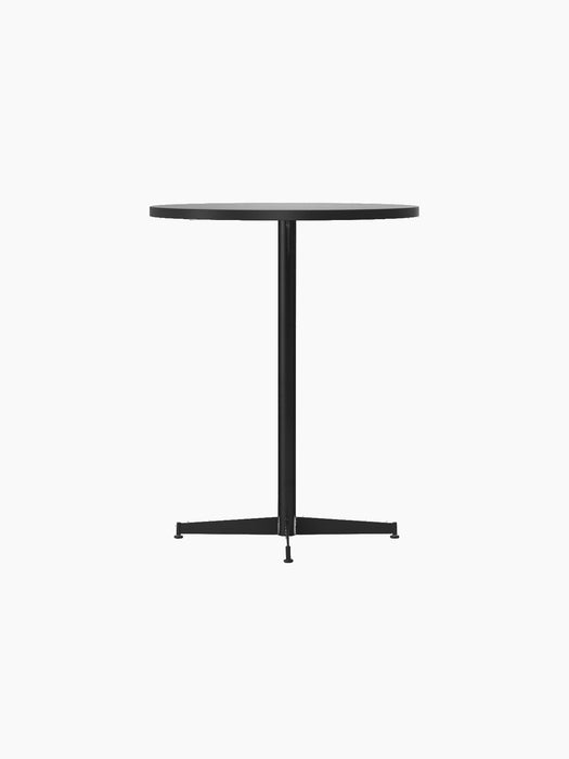 Angled view of the Nook Counter Table, showing its round light tabletop, slim black central column, and four-pronged base.