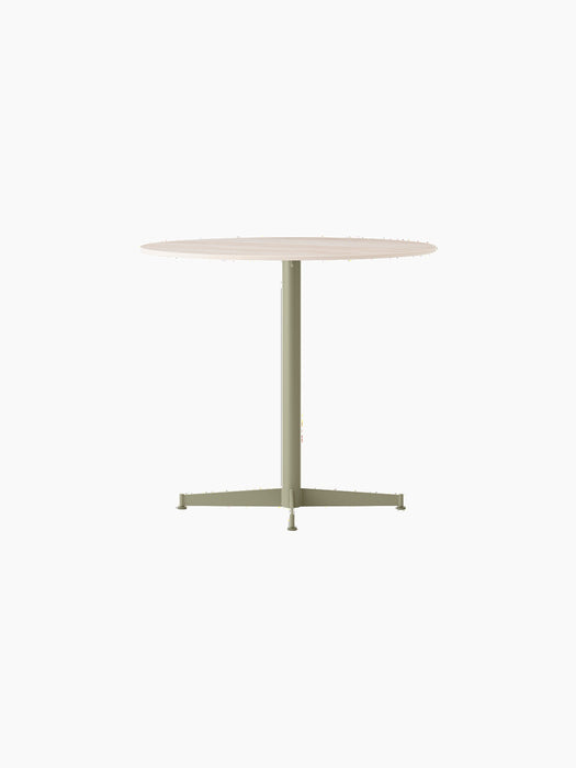 Angle view of the Nook Dining Table, featuring an olive powder-coated steel four-star base and a light round tabletop.
