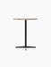 Angled view of the Nook Counter Table featuring a round Kunis Breccia stone top and a slender black powder-coated steel base.