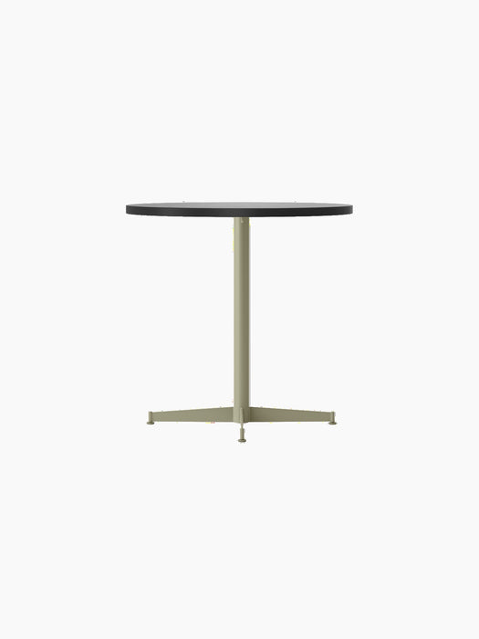 An angle view of the Nook Dining Table, featuring a dark round tabletop and a central olive-coloured steel pedestal base.