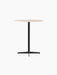 An angled view of the Nook Counter Table, showing its round Kunis Breccia stone top and slender black pedestal base.