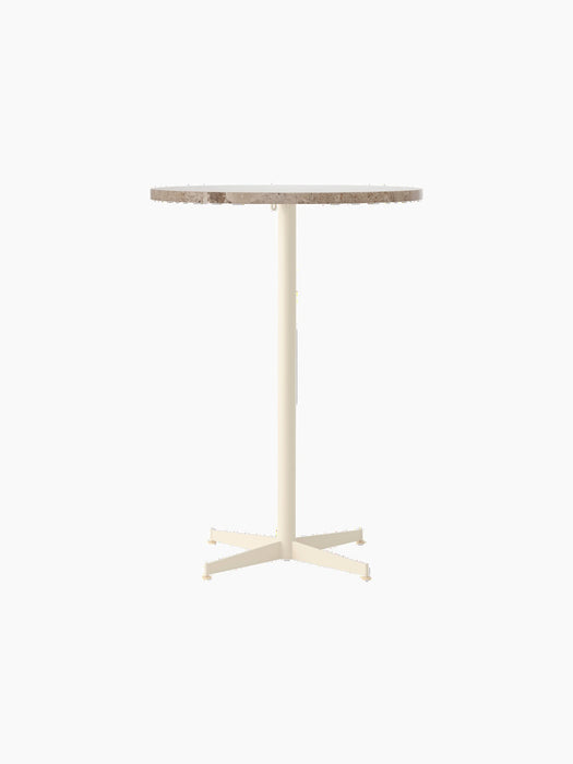Front view of the Nook Bar Table with a round Kunis Breccia stone top on a slender ivory-coloured steel base with four feet.
