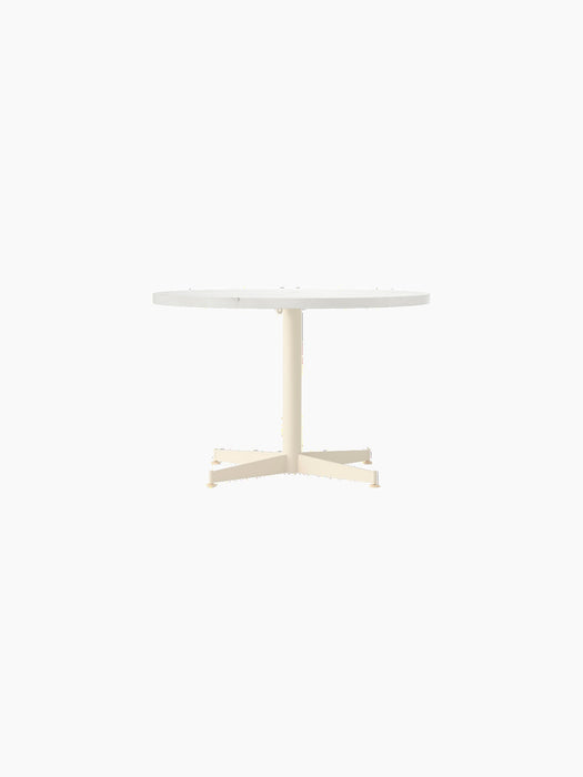 Front view of the Nook Lounge Table with a round Estremoz marble top and a slender, ivory powder-coated four-star base.