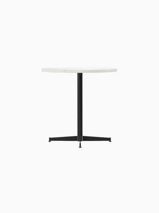 Angled view of the Nook Dining Table, featuring a round white tabletop and a black powder-coated steel four-star base.