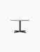 Front view of the Nook Lounge Table, featuring a round Kunis Breccia stone top and a slender black steel four-star base.