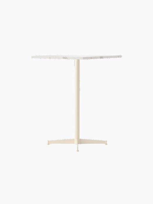 An angle view of the Nook Counter Table with a square white marble top and an ivory powder-coated steel pedestal base.