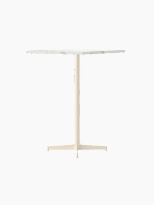 Nook Bar Table with an ivory powder-coated steel base and a round, white Estremoz marble tabletop, viewed from an angle.