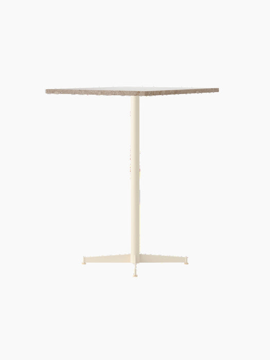 An angled view of the Nook Bar Table with a round Kunis Breccia stone top and a slender ivory-coloured pedestal base.
