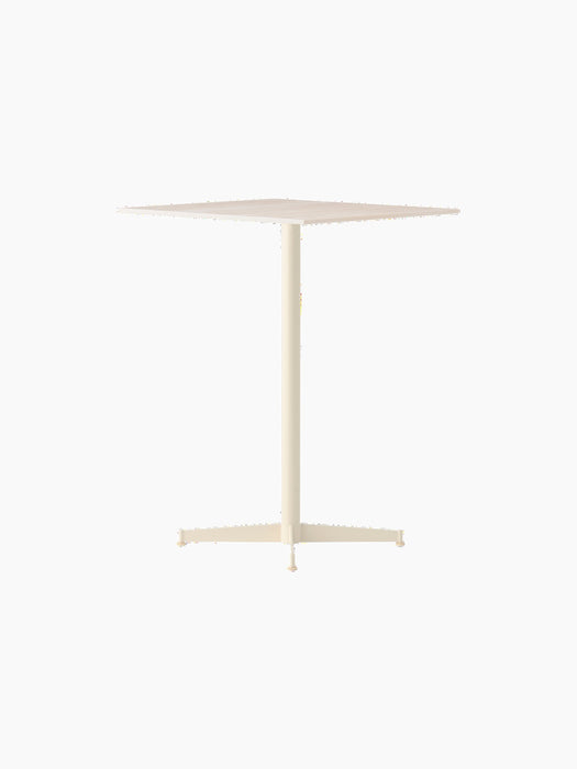 The Nook Counter Table in ivory, at an angle. It features a square tabletop, a slim central column, and a four-leg base.