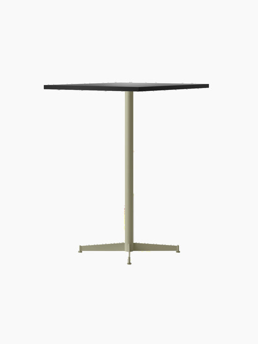 The Nook Bar Table, seen from an angle, featuring a dark rectangular tabletop and an olive-coloured powder-coated steel base.