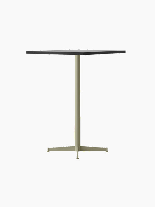 Angled view of the Nook Bar Table with a dark, rectangular tabletop and a slender, olive-coloured pedestal base on four feet.
