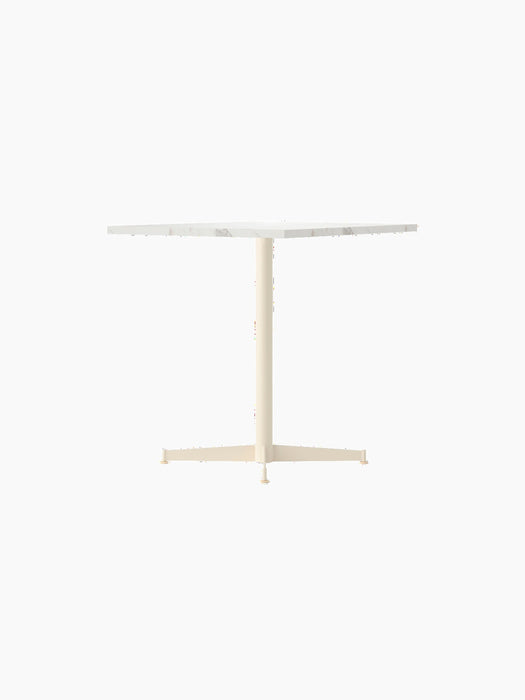 Front view of the Nook Dining Table, featuring a square Estremoz marble tabletop and a slim, ivory-coloured four-star base.