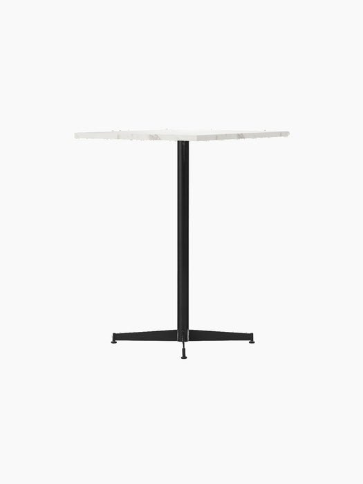 An angled shot of the Nook Counter Table with a white marble top and a slim black steel base, set against a black background.