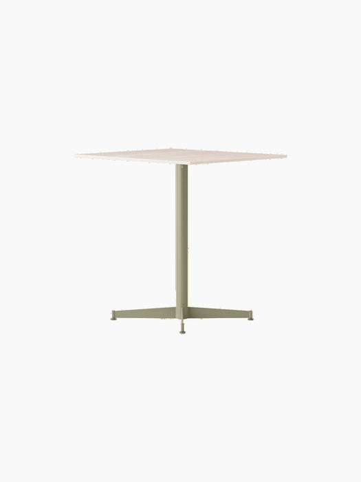 Angled view of the Nook Dining Table with a square, light stone top and a slim, olive green, four-star pedestal base.