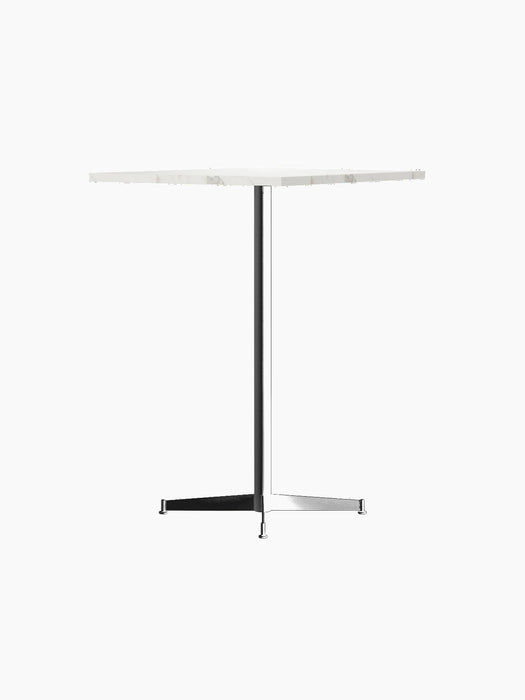 An angle view of the Nook Bar Table, featuring a round white marble top and a slim black powder-coated steel pedestal base.