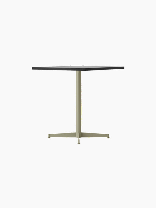 A side view of the Nook Dining Table, with a dark square tabletop and an ivory powder-coated steel base with four legs.