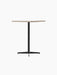 Angle view of the Nook Counter Table, showcasing its textured Kunis Breccia stone top and minimalist black steel central leg.