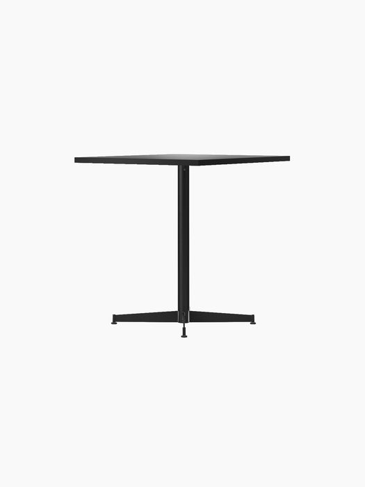 Angled view of the Nook Dining Table, showcasing its rectangular top and slender black powder-coated steel four-star base.