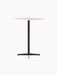 The Nook Bar Table shown from an angle, featuring a square light-coloured tabletop and a black powder-coated steel base.