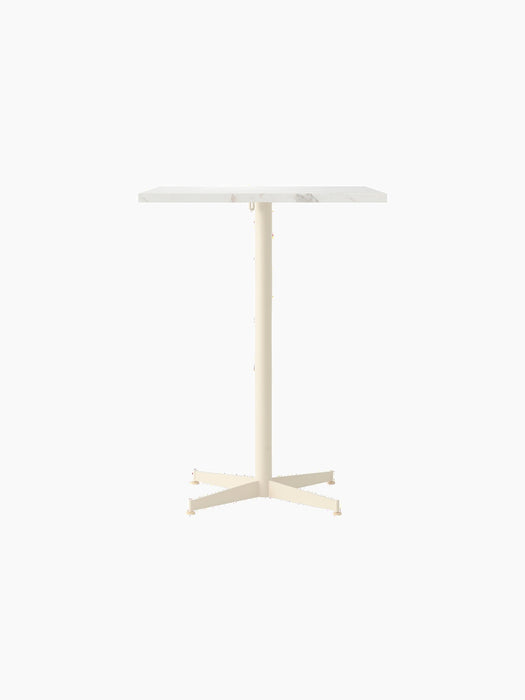Front view of the Nook Counter Table with a rectangular white marble top and slim ivory pedestal base with four feet.