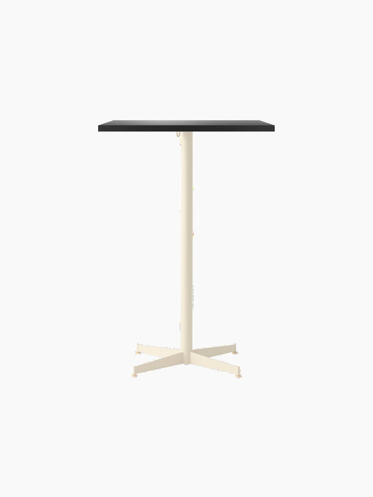 Front view of the Nook Bar Table, with a rectangular dark tabletop and a contrasting ivory, four-pronged steel base.