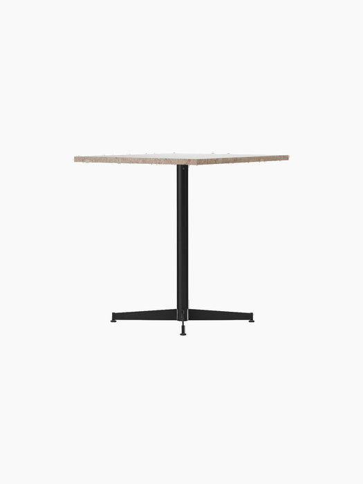 The Nook Dining Table, seen from the side, with a round Kunis Breccia stone top and a slender black four-star metal base.