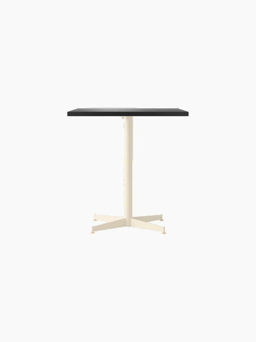 Front view of the Nook Dining Table with a rectangular charcoal linoleum top and an ivory powder-coated steel four-star base.