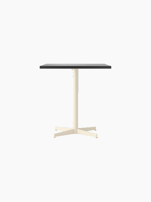 The Nook Dining Table with a rectangular charcoal linoleum tabletop on a slim, ivory, four-star base.