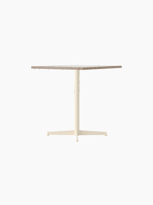 Angle view of the Nook Dining Table, featuring a rectangular Kunis Breccia stone top and an ivory four-star pedestal base.