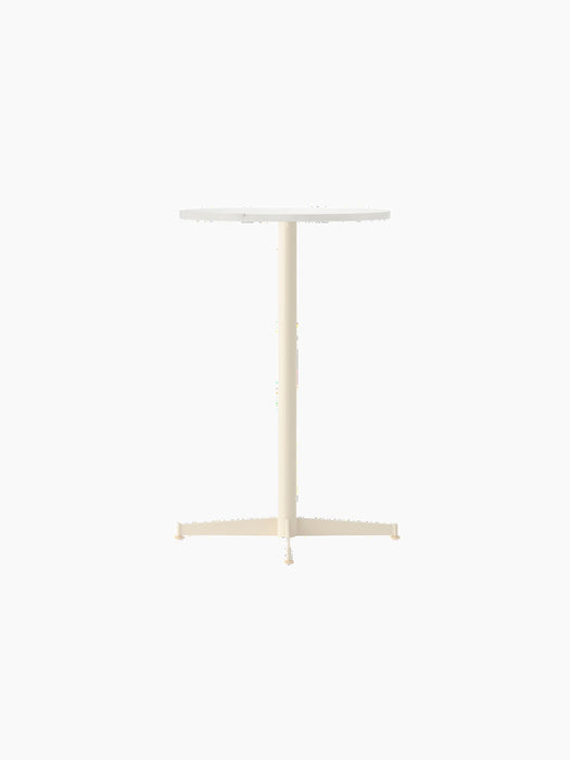Angle view of the Nook Counter Table, featuring a round Estremoz marble tabletop and a slim, four-pronged ivory base.