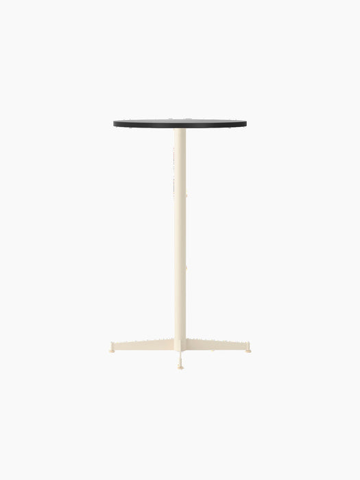 An angled shot of the Nook Bar Table, featuring a round black oak top supported by a slim, ivory-coloured pedestal base.