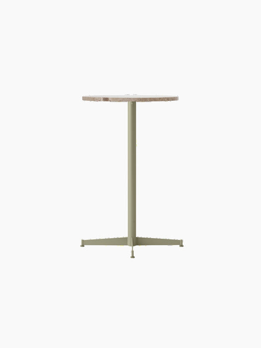 Angled view of the Nook Counter Table with a round Kunis Breccia stone top and an olive powder-coated steel base.