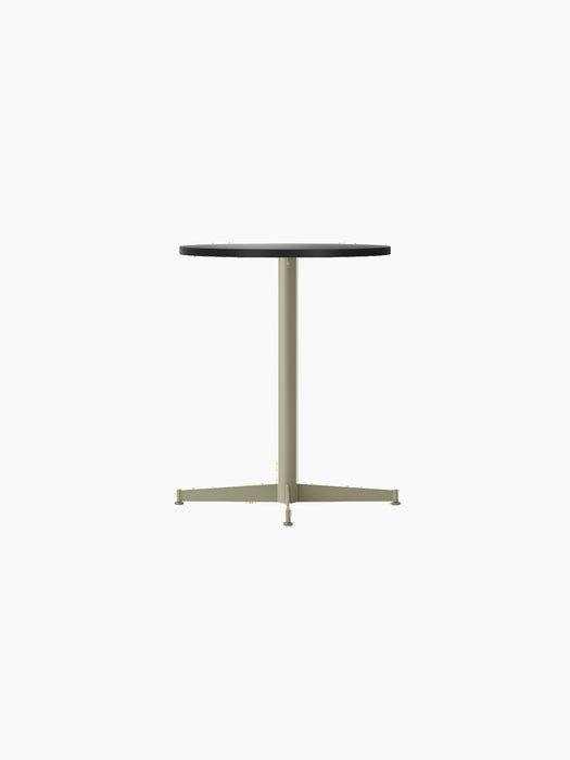 An angled view of the Nook Dining Table, featuring a round charcoal linoleum top and a slim, olive-coloured four-star base.