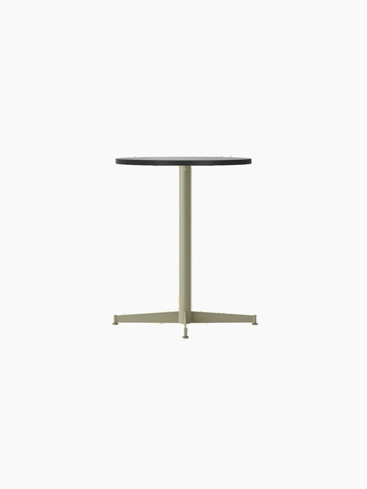 Angled view of the Nook Dining Table with a round black oak veneer top and an olive green powder-coated steel pedestal base.