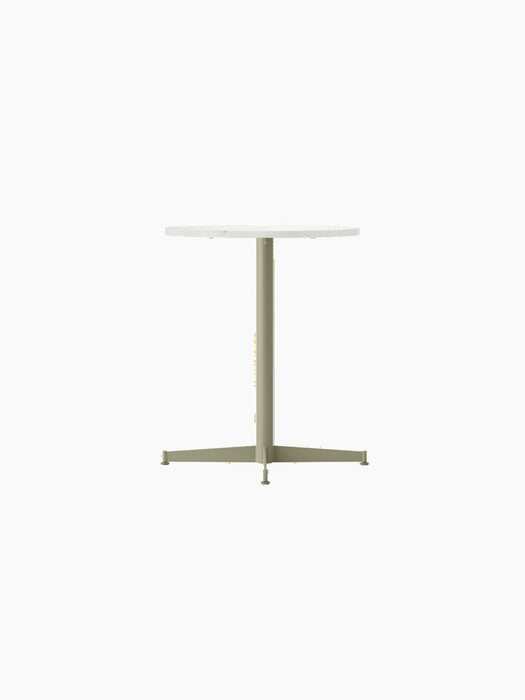 An angled view of the Nook Dining Table, featuring a round Estremoz marble top and a slim, four-star base in olive green.