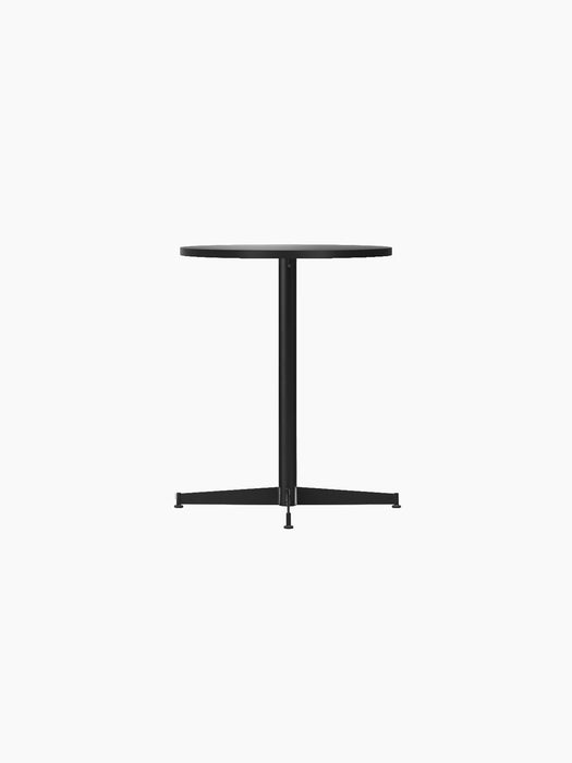 Angle view of the Nook Dining Table with a round charcoal linoleum top and a slim, four-star black steel base.