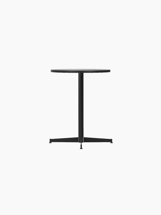 A side view of the Nook Dining Table with a round black oak top and slim, black four-star metal base on a black background.
