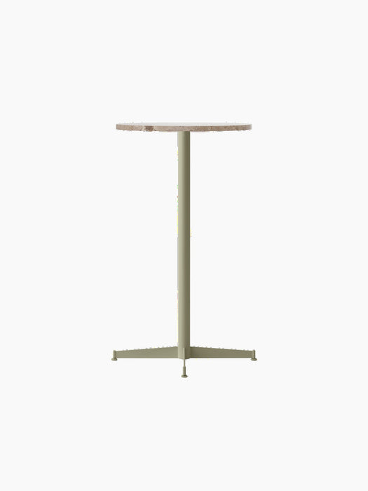The Nook Bar Table with a round Kunis Breccia stone top and an olive green base, shown at an angle on a black background.