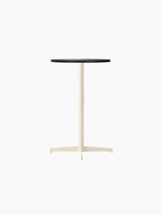 The Nook Counter Table with a round charcoal linoleum top and an ivory powder-coated steel base, shown from an angle.